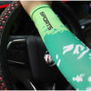A close-up of a lime green sports arm sleeve with white camouflage print on a person's arm, being held near a steering wheel.