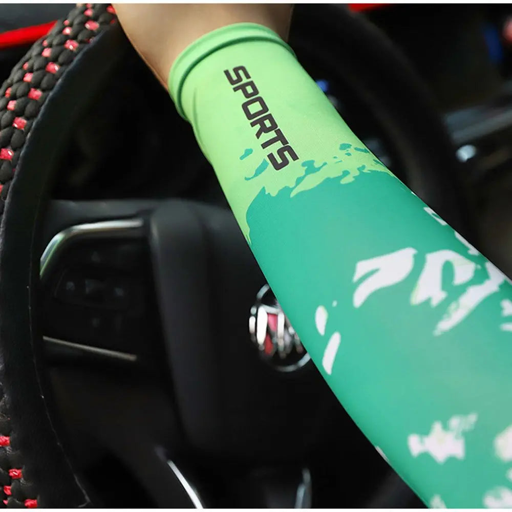 A close-up of a lime green sports arm sleeve with white camouflage print on a person's arm, being held near a steering wheel.