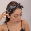A woman wearing a black paisley bandana headband on her hair.