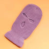 A purple tactical knit balaclava beanie hat lying on an orange background.
