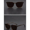 Brown tinted square sunglasses resting on a dark surface.