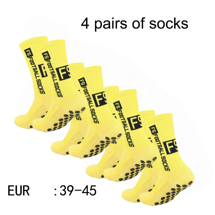 Four pairs of yellow athletic soccer socks with black non-slip grips displayed together.