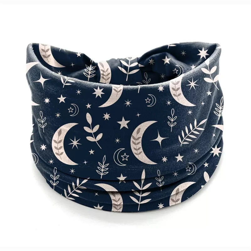 Dark blue bohemian stretch cotton headband featuring a pattern of crescent moons, stars, and leaves.