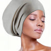 A woman wearing a sage green silicone swim cap for long hair and braids.