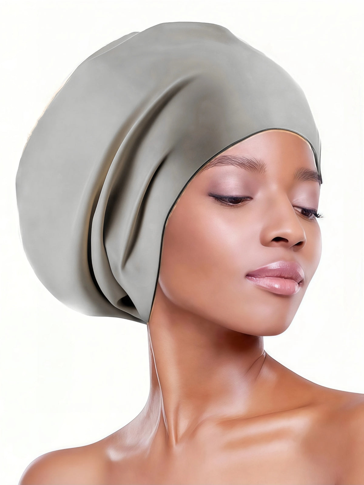 A woman wearing a sage green silicone swim cap for long hair and braids.