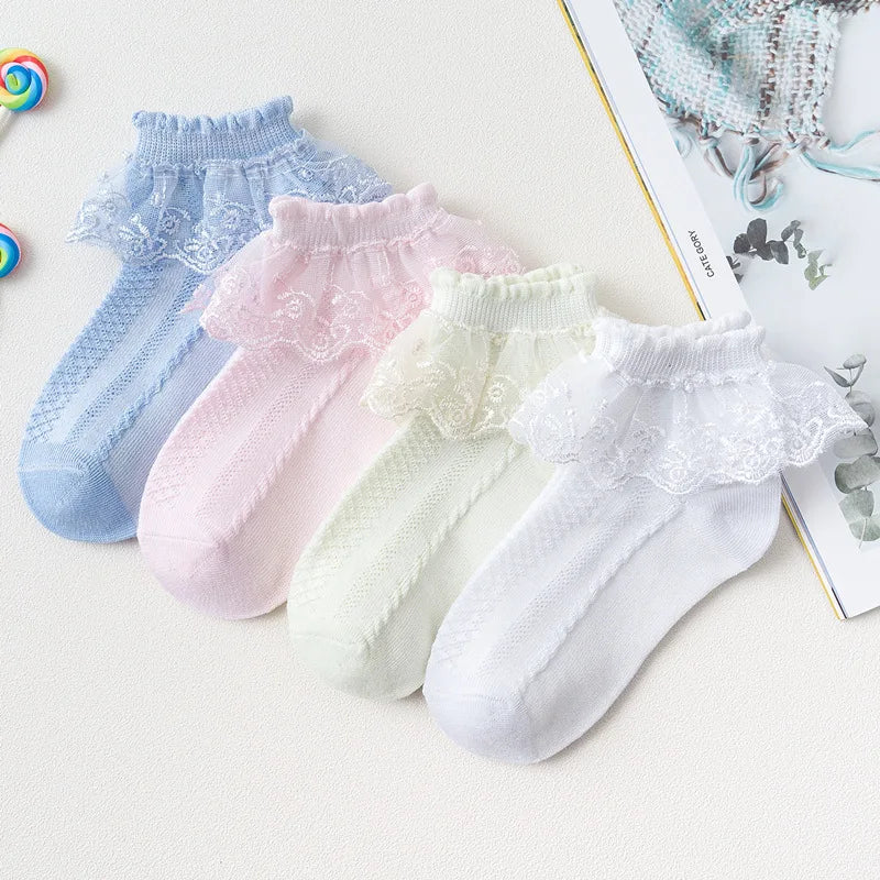 Collection de chaussettes à volants en dentelle pastel pour filles, dans des tons de bleu, rose et blanc.