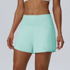 Eine Frau modelliert leichte mintgrüne, schnelltrocknende Sportshorts.