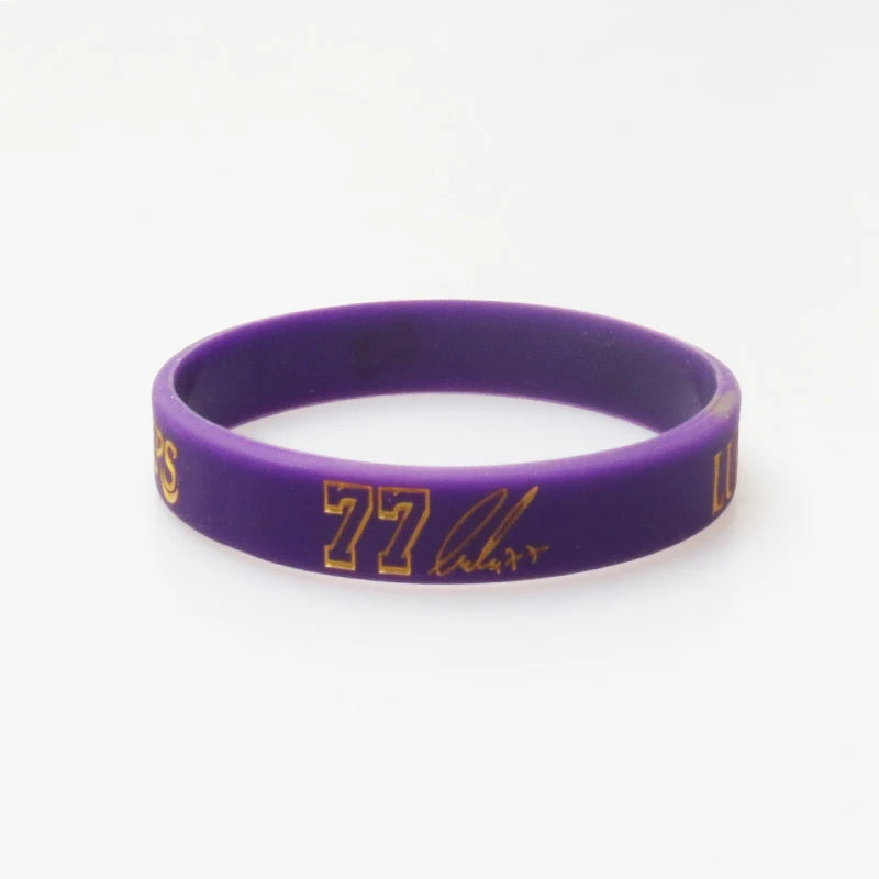 Purple silicone wristband with gold lettering displaying 77 Larry