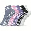 A row of colorful non-slip grip socks for yoga and pilates in various shades of gray, pink, purple, black, and white.