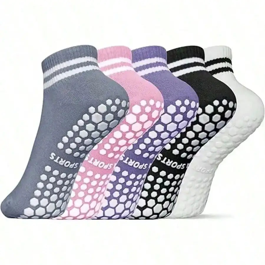 A row of colorful non-slip grip socks for yoga and pilates in various shades of gray, pink, purple, black, and white.