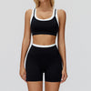 Eine Frau trägt ein schwarz-weißes Yoga- und Sportanzug-Set (Oberteil und Shorts).