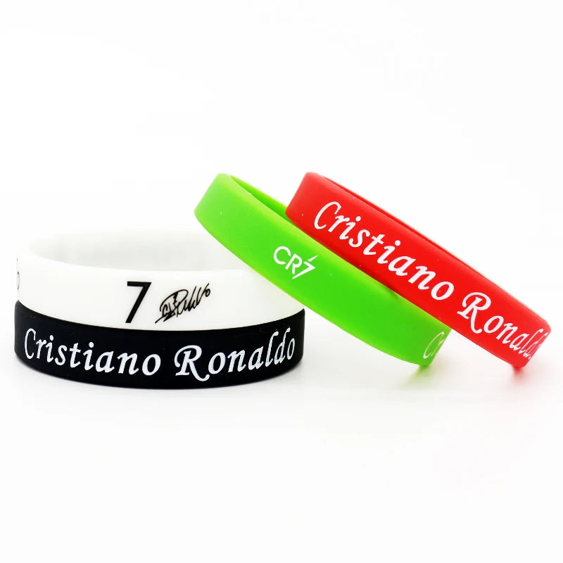 Zwei Silikonarmbänder, eines grün und eines rot, mit dem Namen Cristiano Ronaldo.