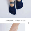 A pair of dark blue silicone yoga socks with a half toe design shown on a foot.