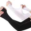 A pair of white and black ice sleeves for sports and outdoor activities being worn on a person's leg.