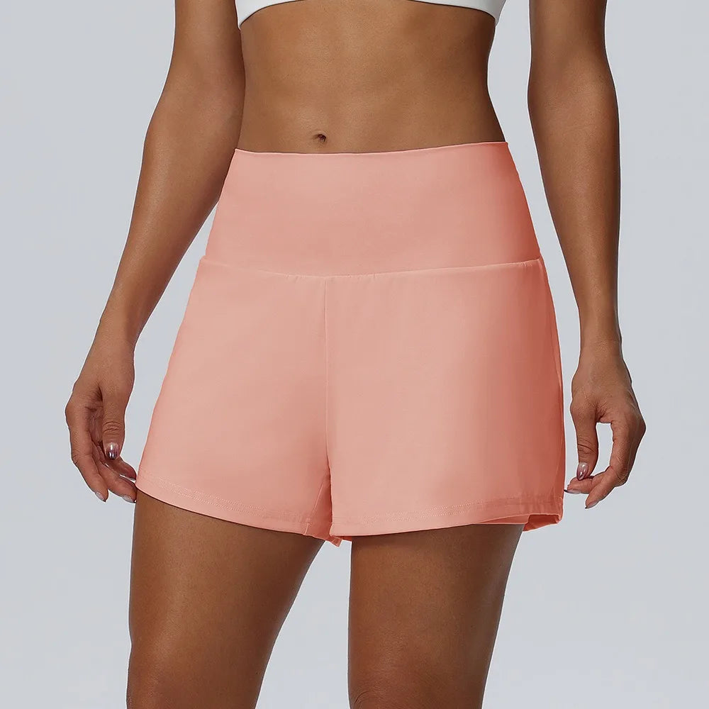Eine Frau trägt leichte, pflegeleichte Sportshorts in Pfirsichfarbe.