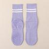 Pair of light purple non-slip yoga socks with white stripes and textured soles