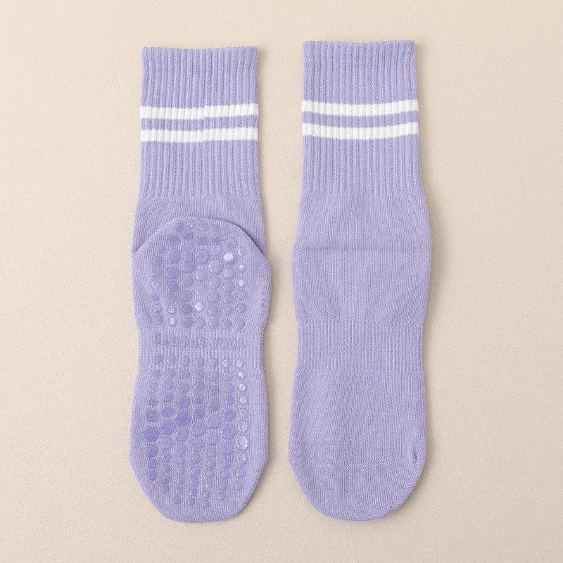 Pair of light purple non-slip yoga socks with white stripes and textured soles