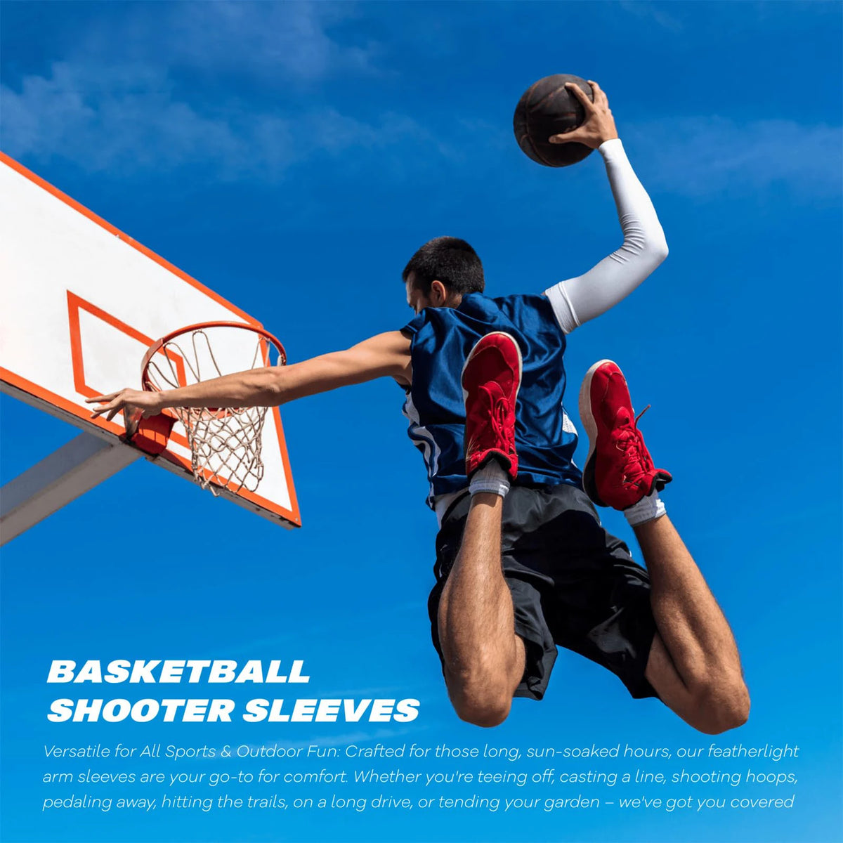 A male basketball player shooting a ball outdoors, wearing blue and black arm sleeves.