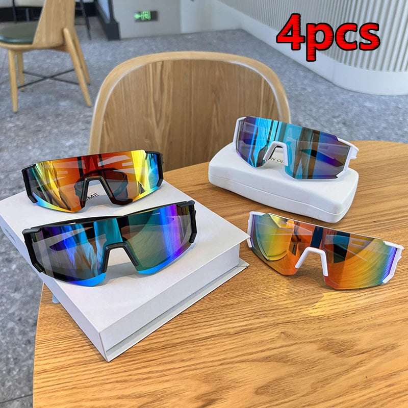 Four pairs of colorful UV400 cycling sunglasses displayed on a wooden table.