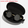 A black velvet box containing a pair of round sunglasses with gold accents.