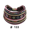A colorful, patterned boho polka dot knotted headband worn around a head.