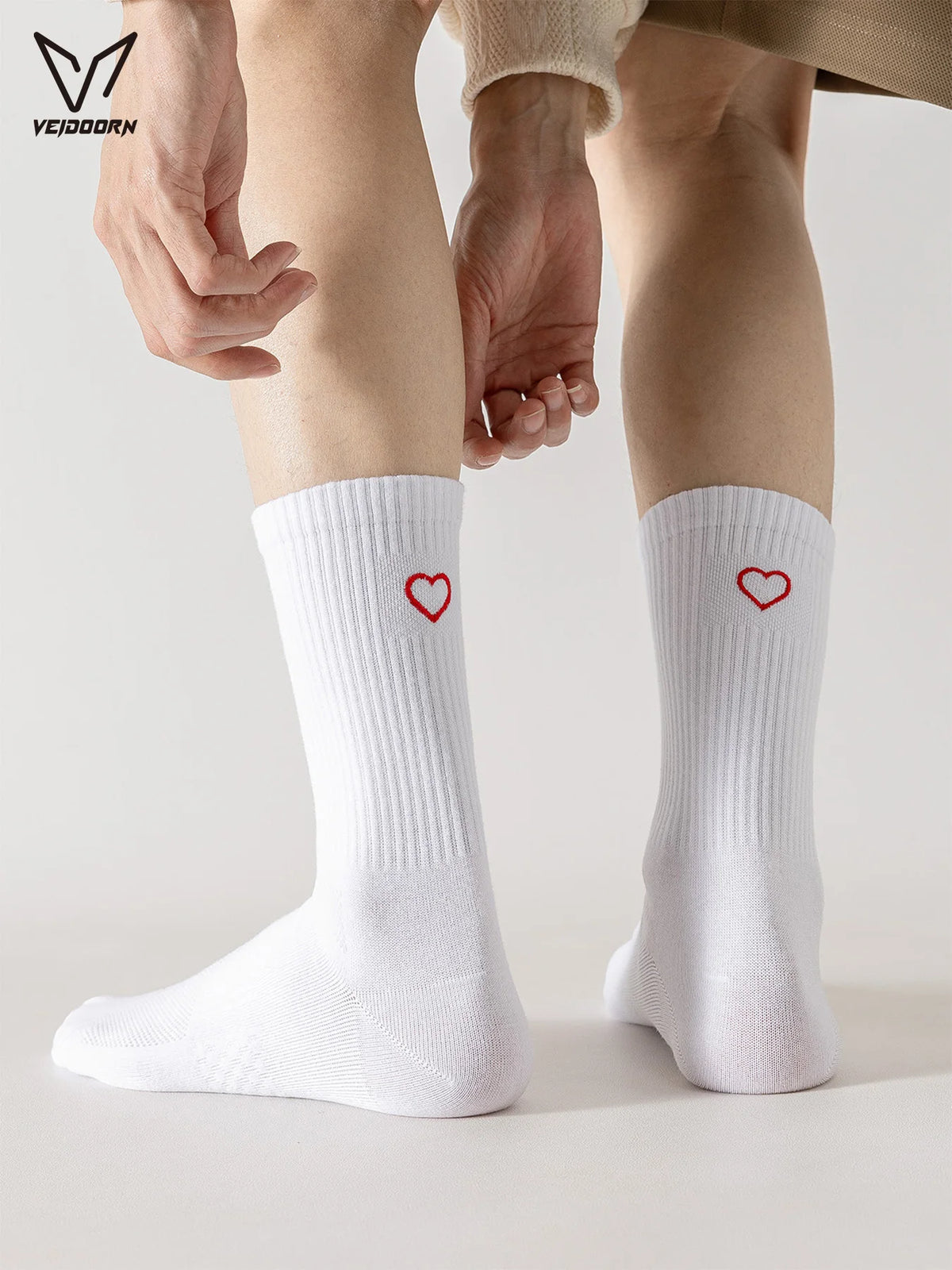 White crew socks with heart embroidery worn on a person's leg.