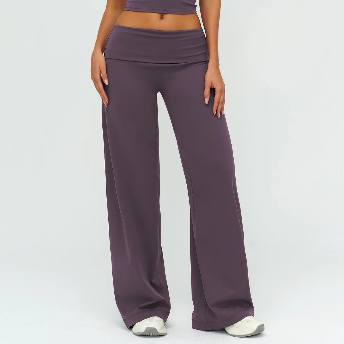 A model wearing mauve flared high-waist yoga pants and a matching crop top.