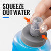 Hand squeezing water out of a blue collapsible TPU bottle.