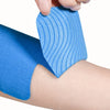 Eine Hand trägt blauen Kinesiologie-Tape auf eine Sprunggelenk, wobei das strukturierte Tape und ein blaues Verband darunter 