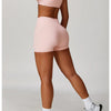 A woman models a pink 3-piece yoga sports set consisting of a crop top, brief, and shorts.