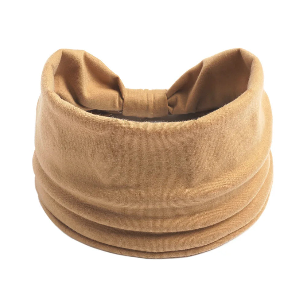 Un foulard en coton bohème beige noué en nœud, vu de dessus.