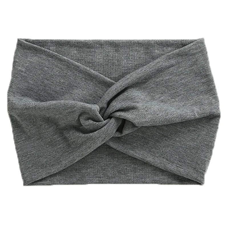 A gray women's elastic sports headband tied in an X shape.