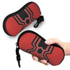 A red and black patterned pouch designed to hold eyeglasses, being held by a hand.