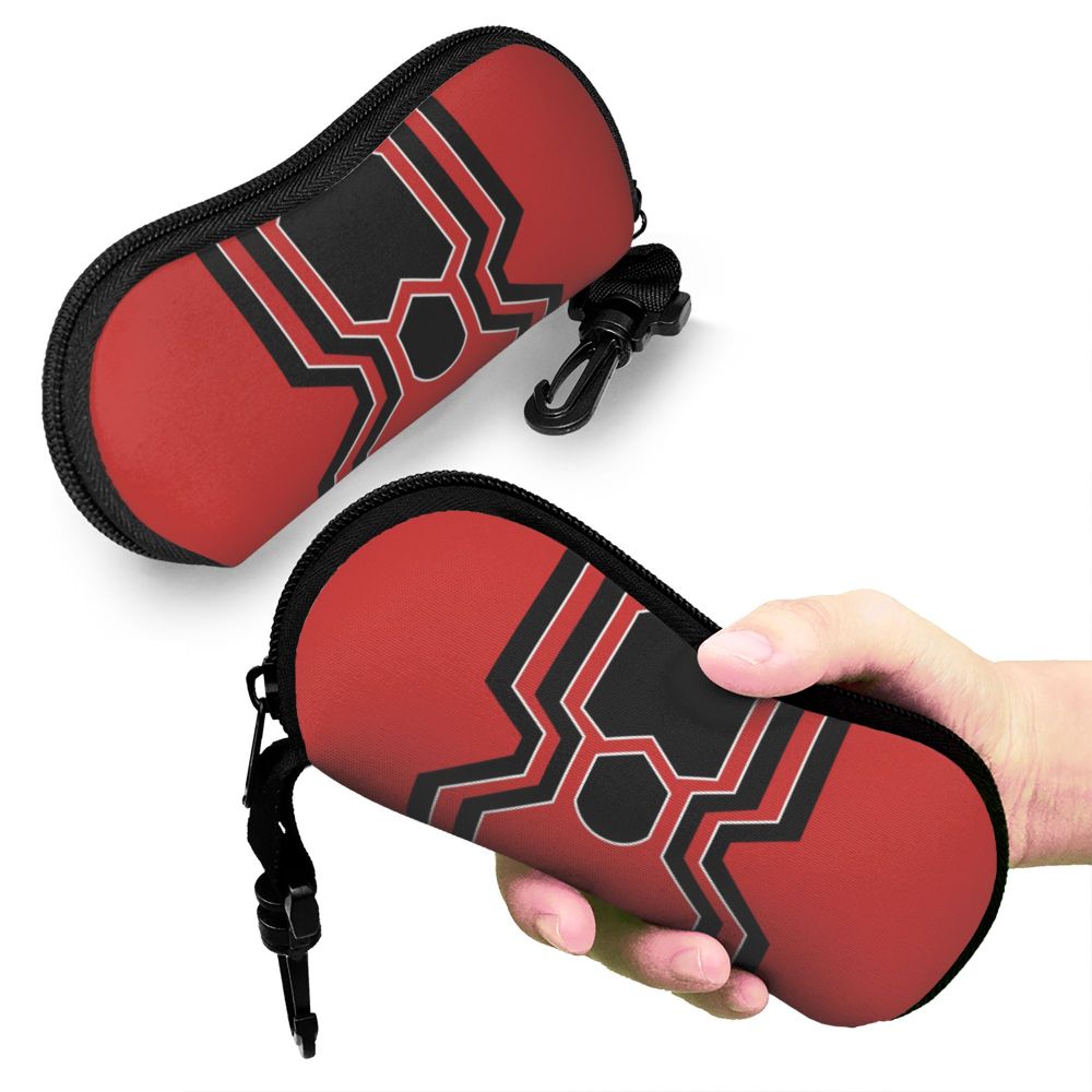 A red and black patterned pouch designed to hold eyeglasses, being held by a hand.