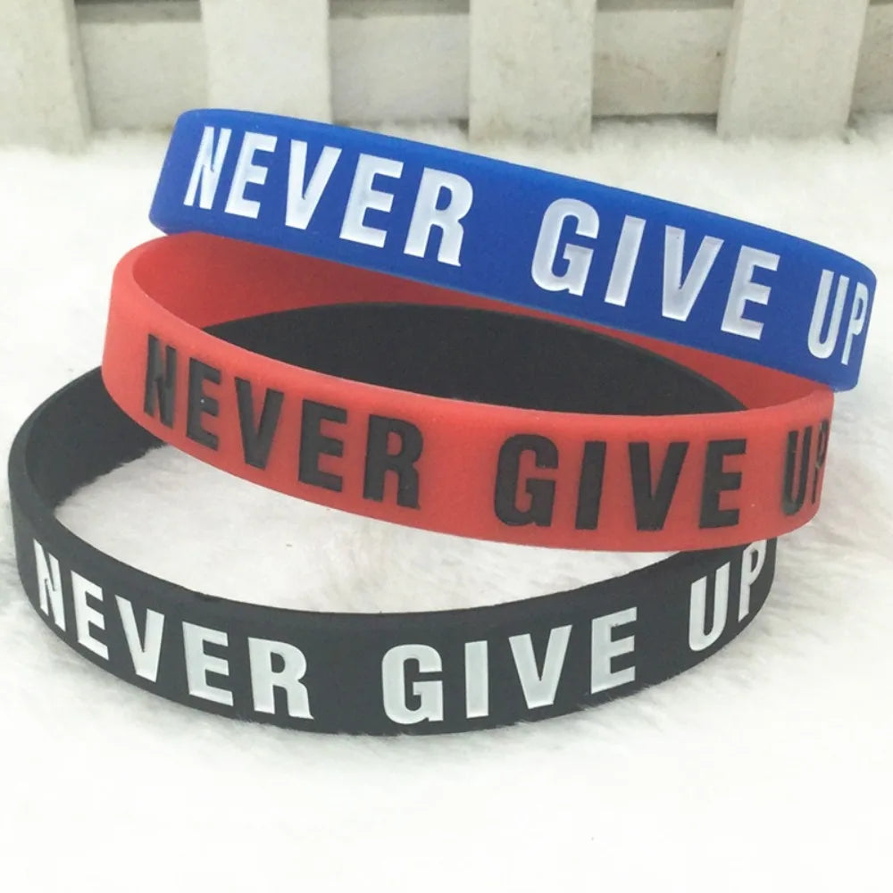 Trois bracelets en silicone bleu, rouge et noir avec le texte Never Give Up