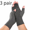 Three pairs of gray therapeutic compression wrist gloves being held by a hand.