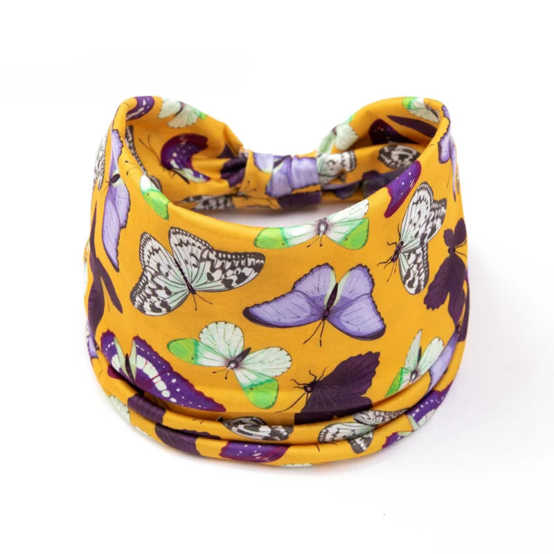 A yellow fabric headband featuring a pattern of purple and green butterflies.