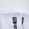 A close-up of white men's athletic soccer socks with black text branding.