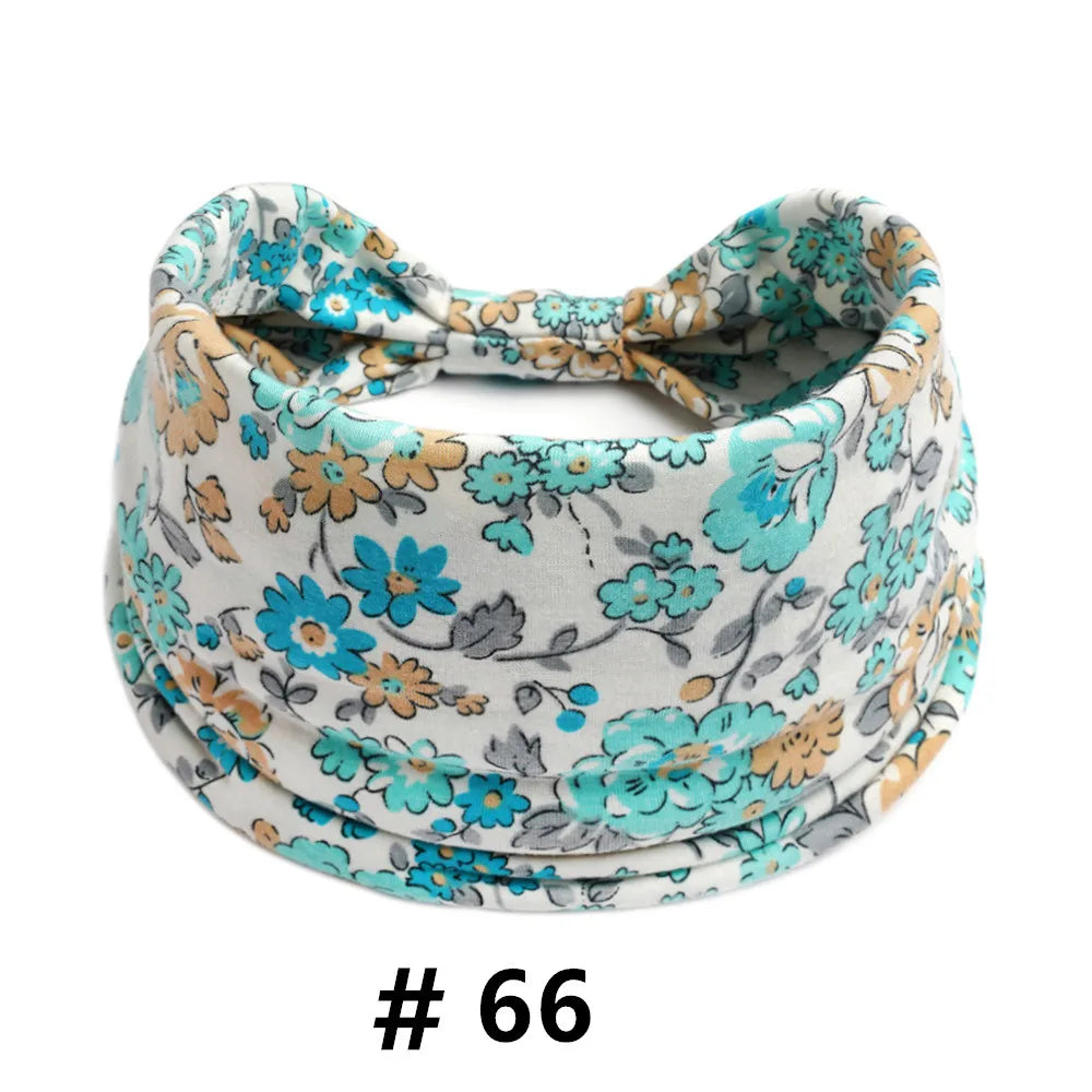 Bandeau en tissu à motifs floraux avec un nœud, orné de fleurs bleues et oranges sur fond blanc.