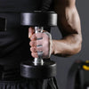 A person is holding a black dumbbell with silver plates using ergonomic anti-slip gym lifting gloves.