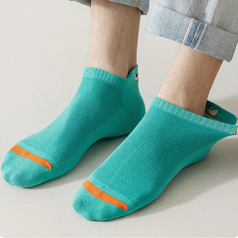 A pair of teal knitted ankle boat socks with an orange accent on the toe, worn on a person's foot.