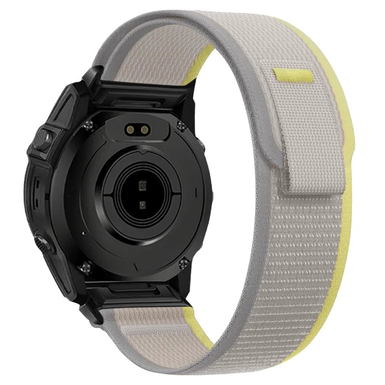 A black Garmin sports watch with a light gray nylon strap and a yellow accent.