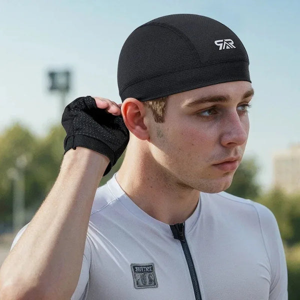 A man wearing a black cycling cap and white shirt outdoors.