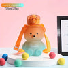 A gradient orange blue bear-shaped water bottle with a straw and strap sitting on a white stand.
