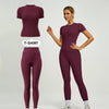 Model in a maroon sports suit with a short-sleeved top and leggings.