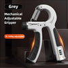 A grey mechanical adjustable gripper hand strengthener is shown in a close-up view.