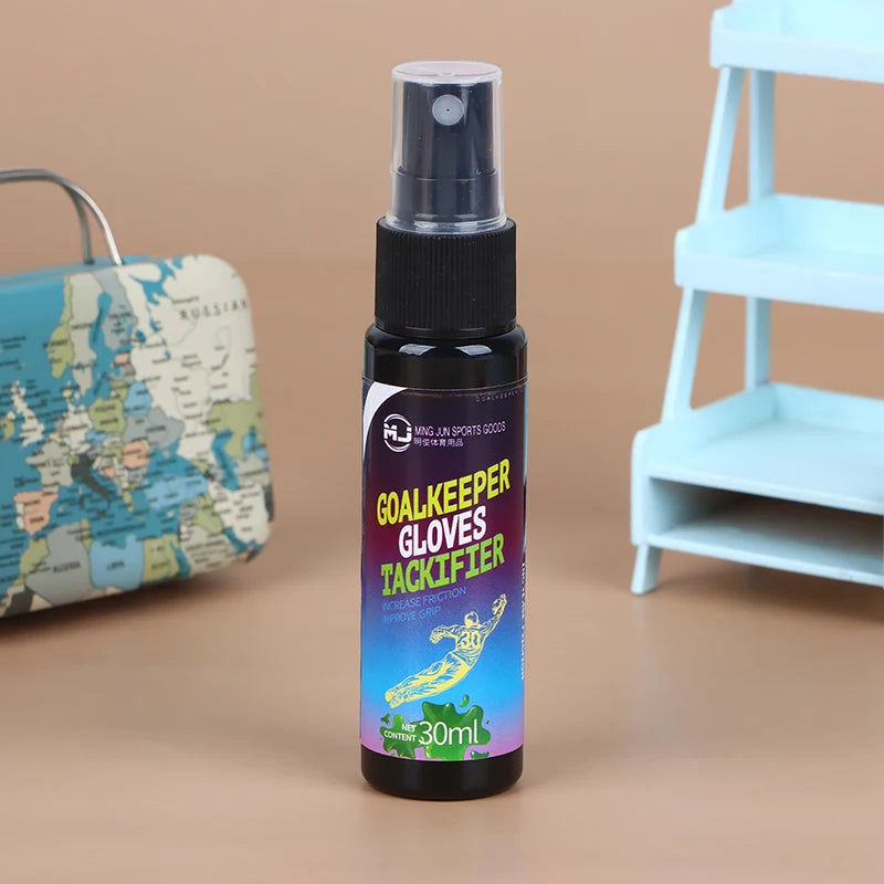 A dark bottle of Goalkeeper Gloves Tackifier spray with a black pump dispenser sits on a brown surface.