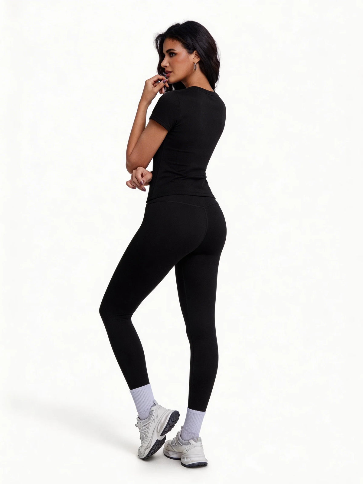Una mujer vistiendo un conjunto de yoga sin costuras y cintura alta negro para entrenamientos intensos.