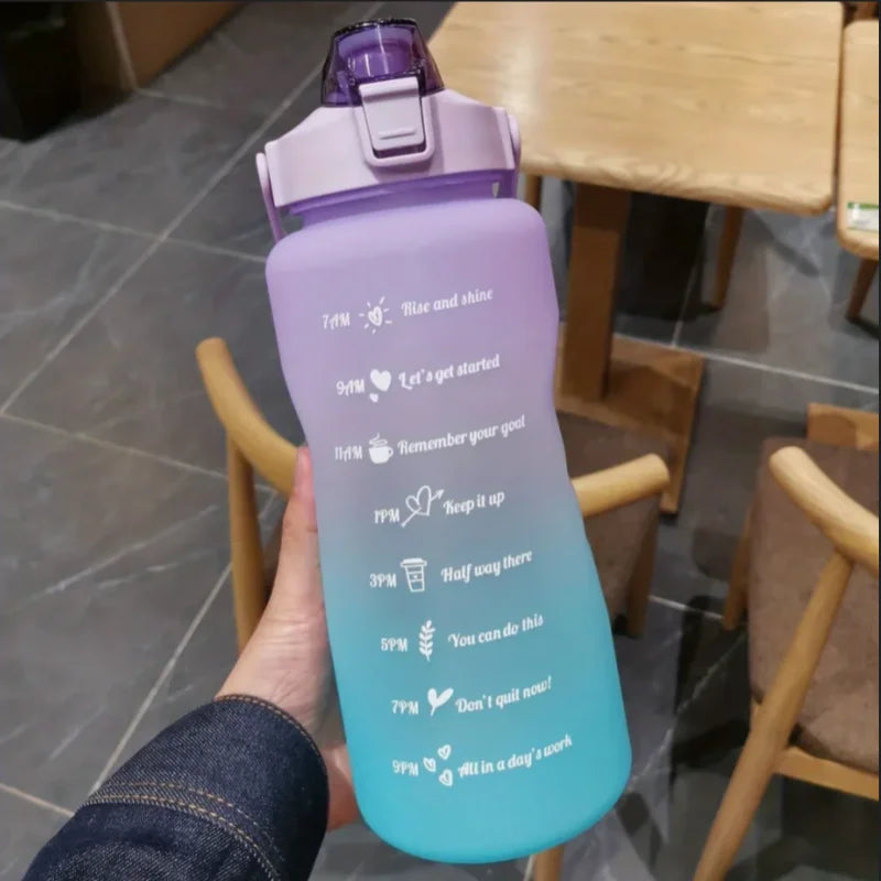 Una mano sostiene un set de botellas deportivas para agua con degradado morado y pajita, con texto motivacional en el cuerpo.