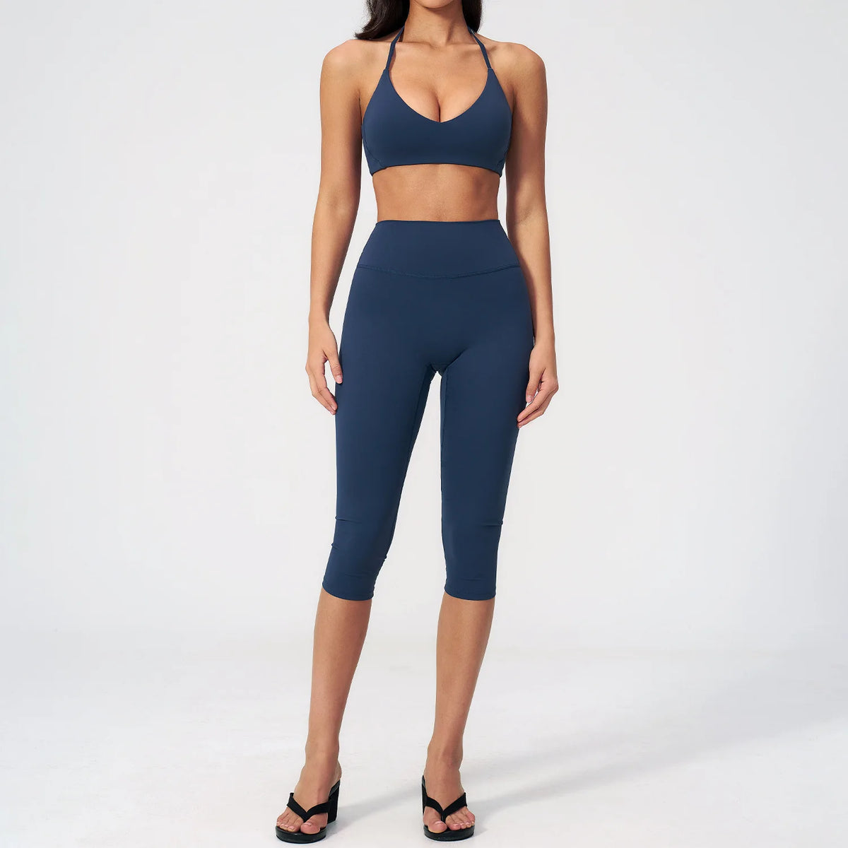 A woman wearing a navy blue women's premium fitness tracksuit top and leggings.